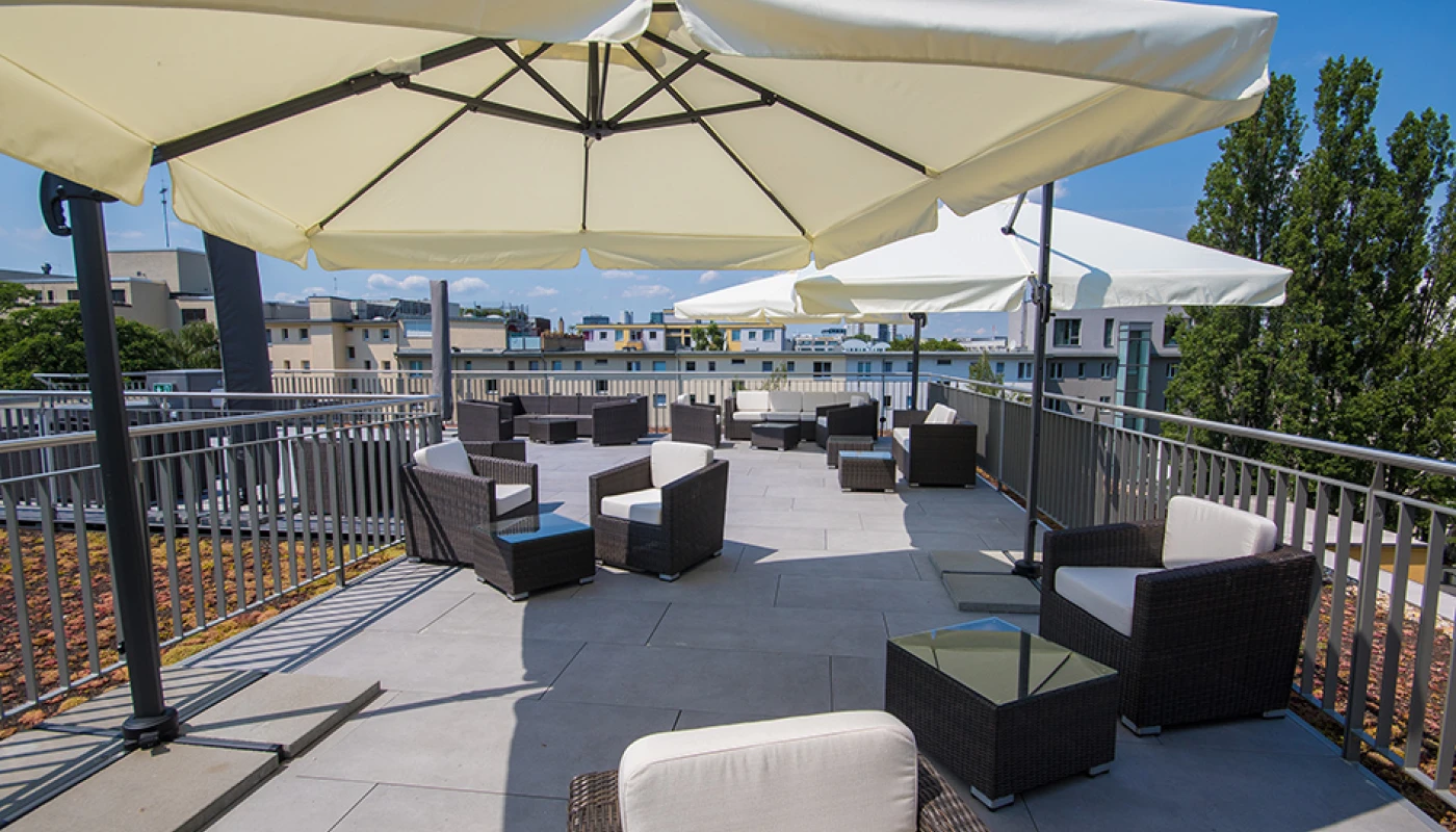 Loungebereich auf der Dachterrasse mit Blick auf umliegende Wohnhäuser