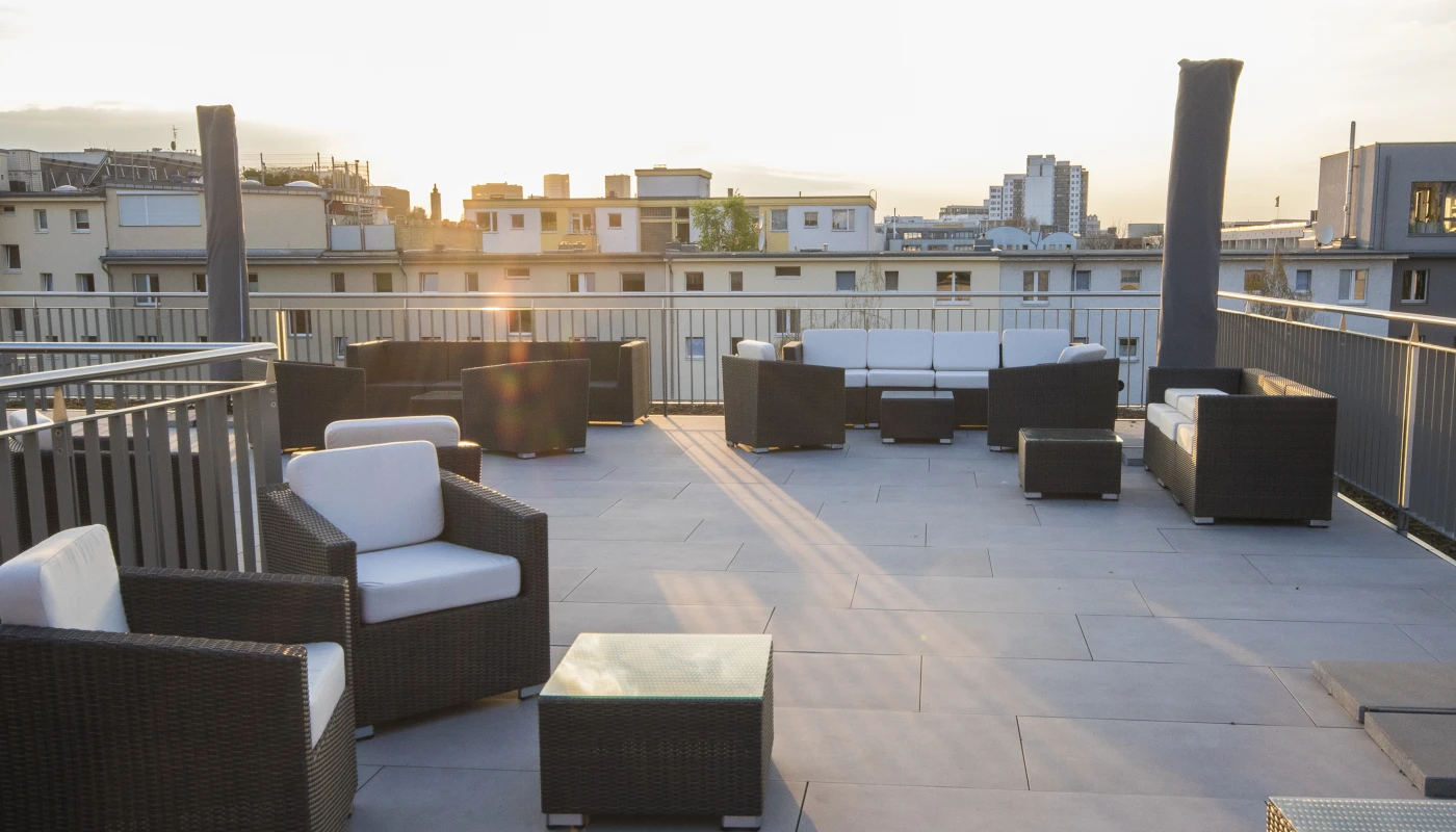 Dachterrasse mit Sonnenschirmen und gemütlichen Rattanmöbeln