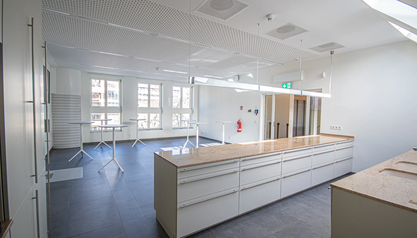 Küchenbereich in der Lounge mit weißen Schränken zum Aufziehen