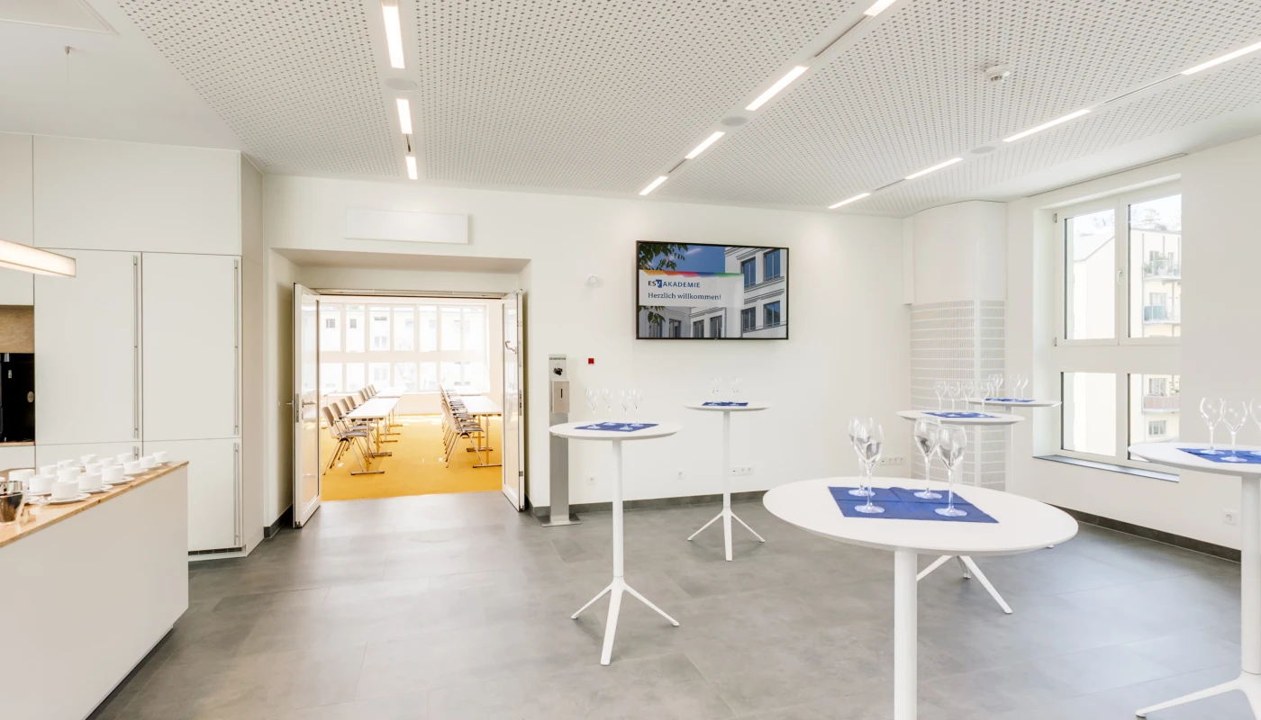 Moderner Loungebereich mit Stehtischen und Gläsern auf blauen Servietten