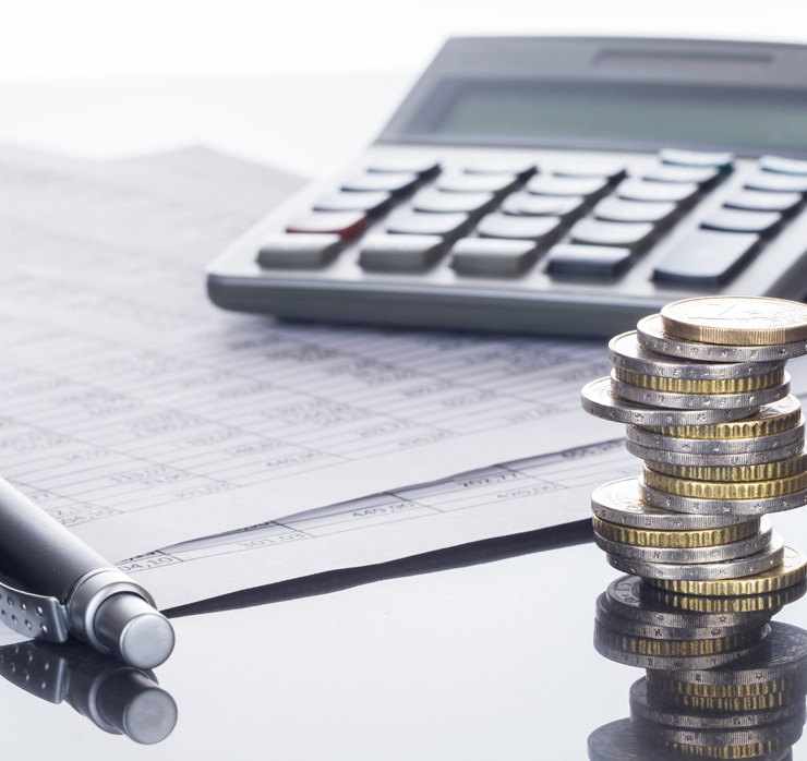 Euro-Münzen auf Finanzdokumenten mit Taschenrechner als Symbol für Finanzierungsstrategien, Investitionen und Unternehmensplanung