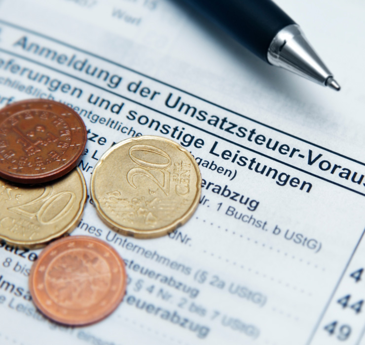 Umsatzsteuerformular mit Münzen als Symbol für Besteuerung der öffentlichen Hand