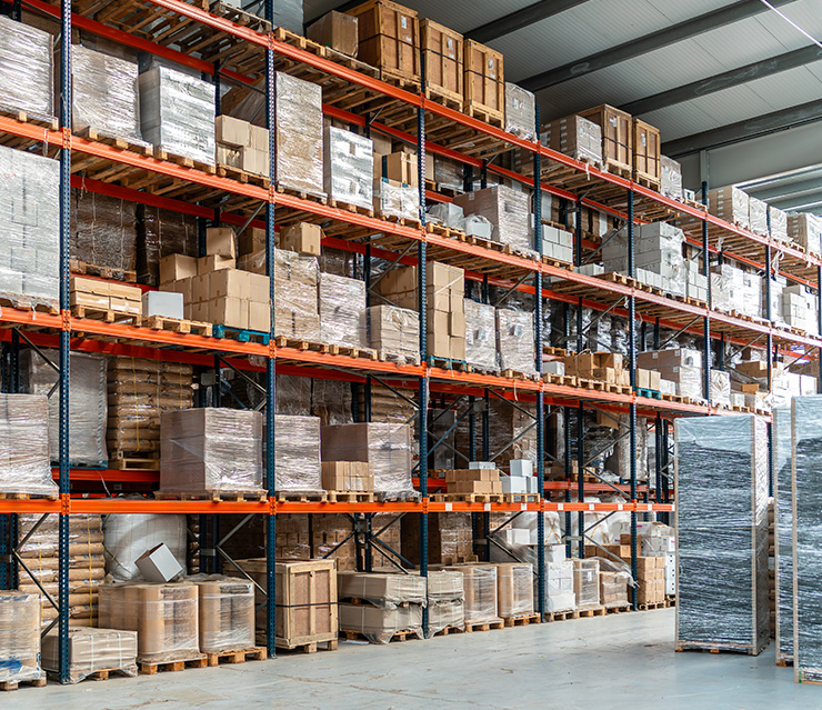 Hochregallager mit zahlreichen Paletten und Warenbeständen als Symbol für Kapitalbindung, Lagerhaltung und Liquiditätsmanagement in Unternehmen.
